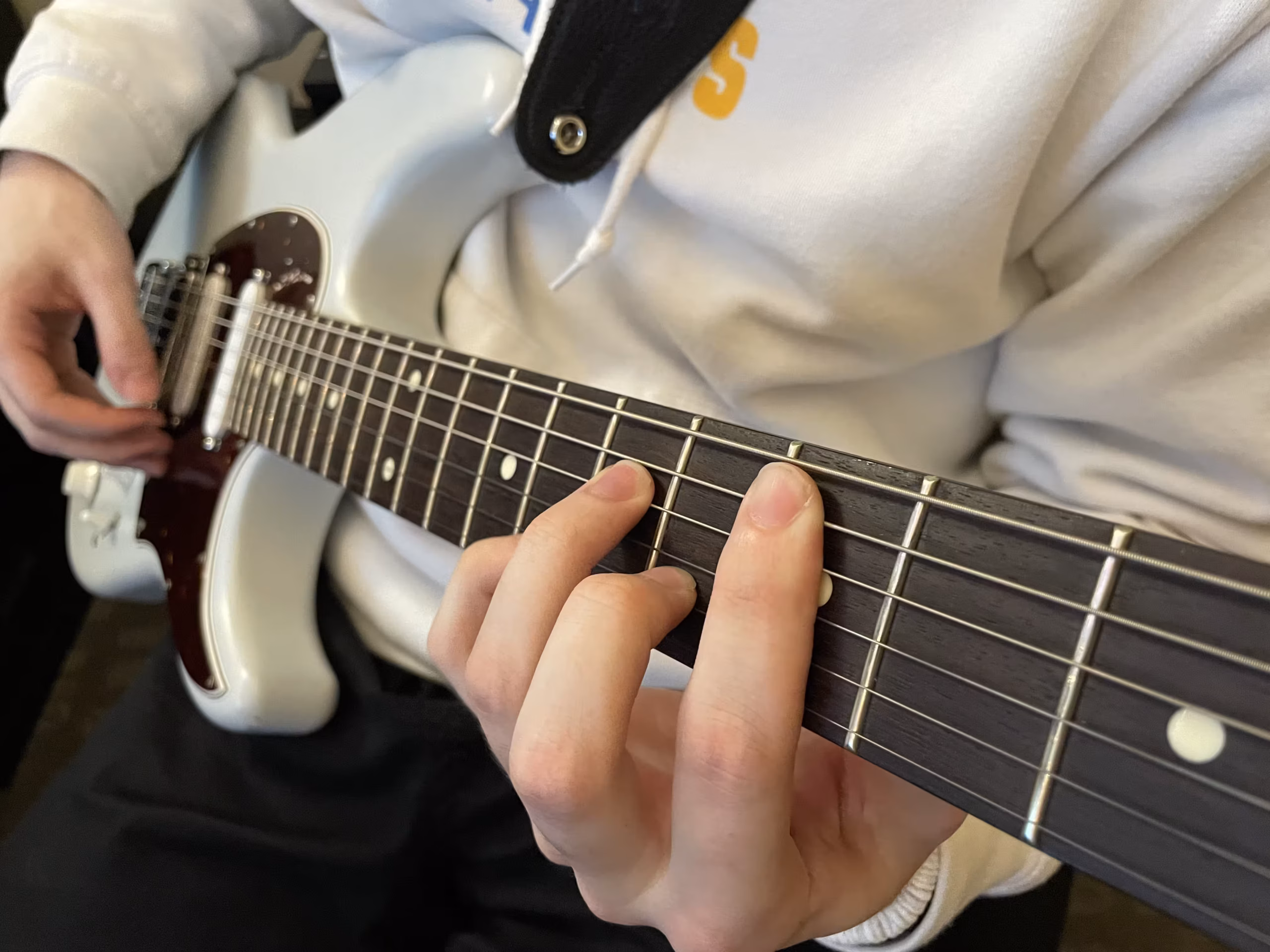 A Student playing guitar during a recital at Silversound Guitar
